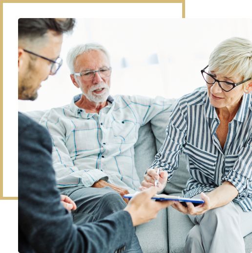 Senior couple reviewing documents with advisor.